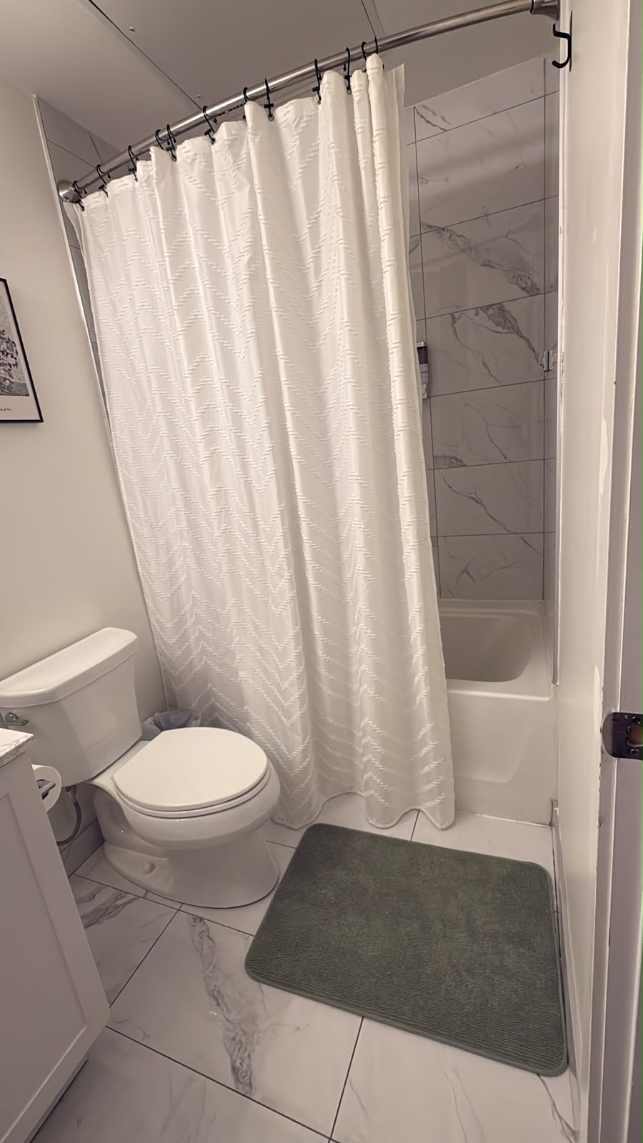 Clean Airbnb shower, tub, toilet, and fresh bath mat