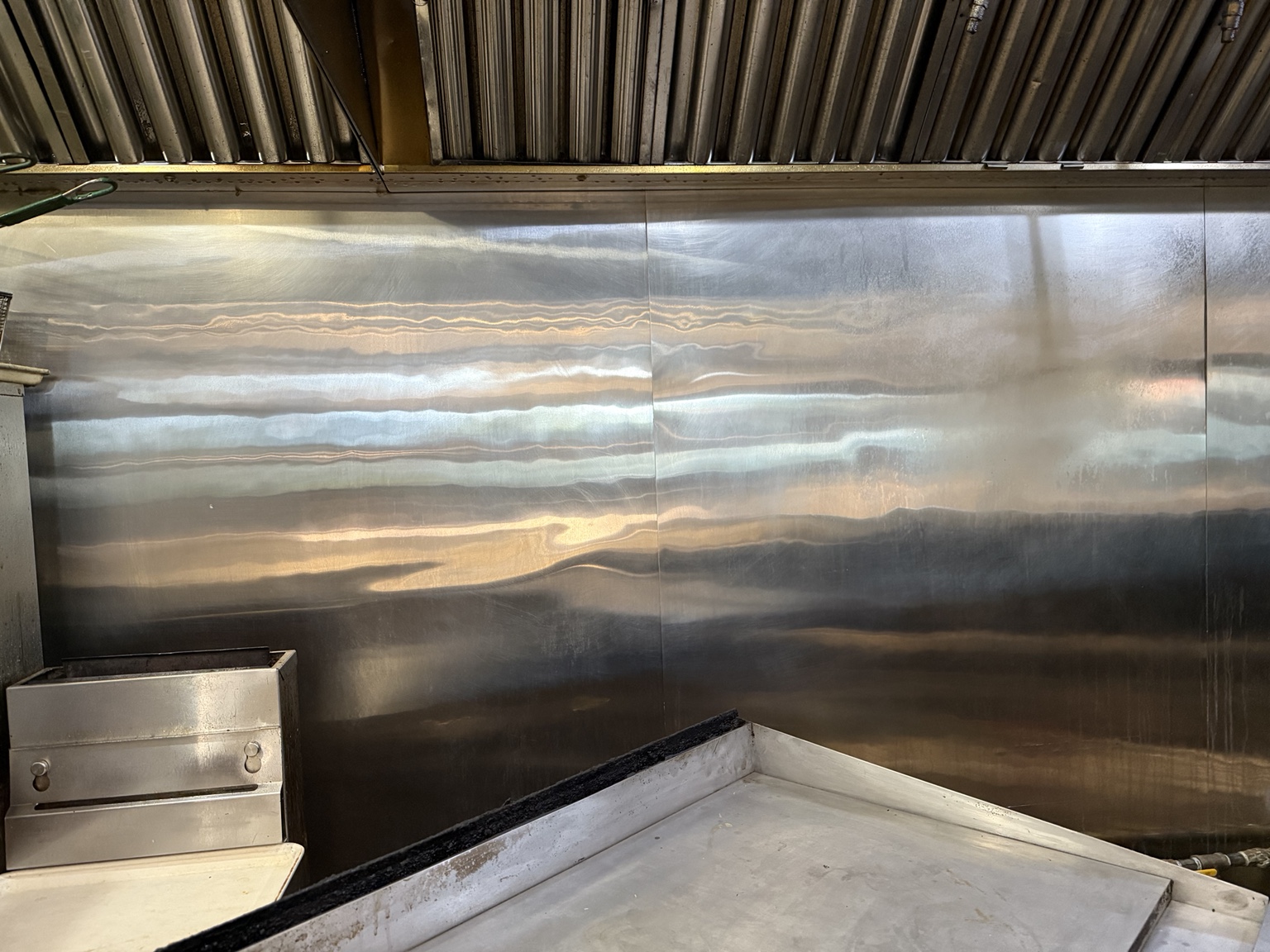 Commercial kitchen stainless-steel wall after cleaning
